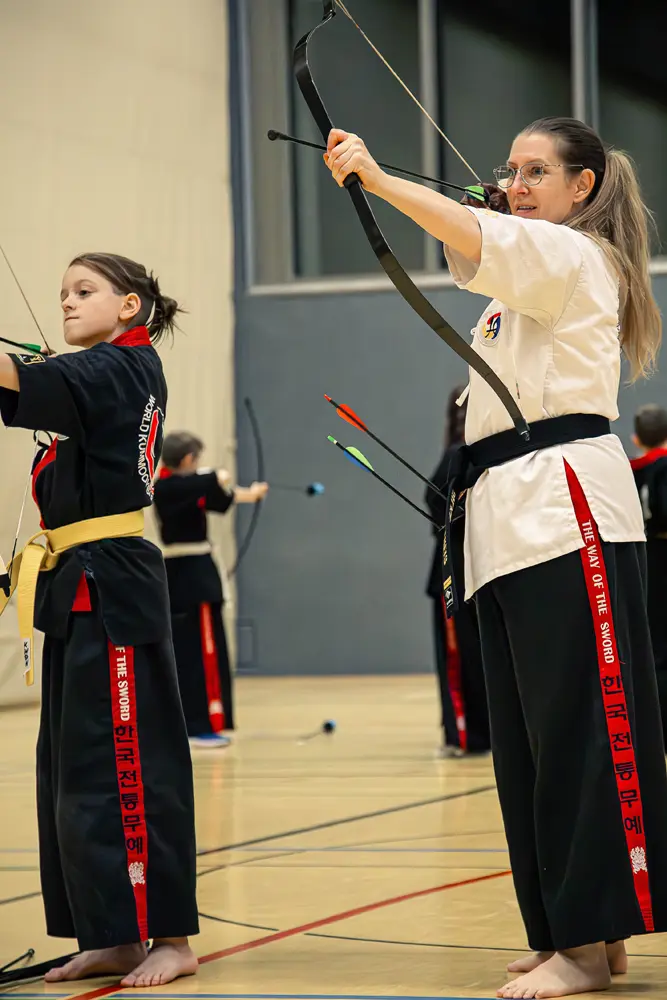 Die ehrenamtliche Übungsleiterin Silke Theis und ein Kind, üben Kummooyeh, eine koreanische Kampfkunst.